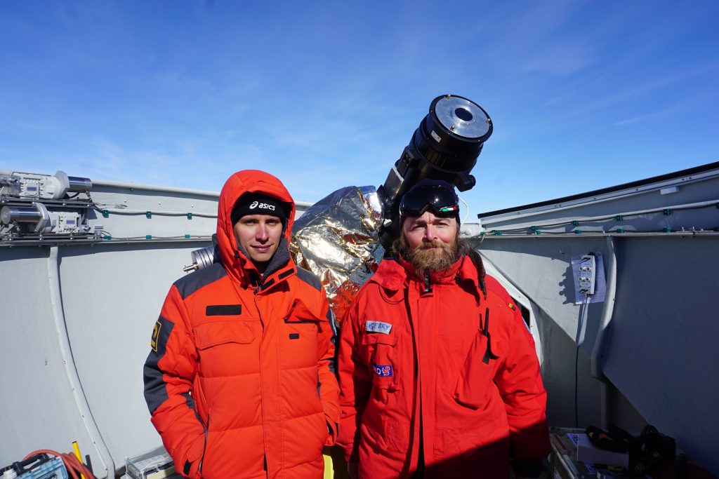 Gerardo Capobianco (OATo researcher and Alessandro Liberatore (PhD student at the University of Turin) next to the AnctarctiCor instrument at the Concordia station in Antarctica Copyright: G. Capobianco, A. Liberatore @ PNRA